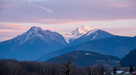 Sunset in the mountains with snowcapped peaks in the backgroundの素材