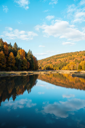 Autumn landscape with colorful forest and lake. Colorful autumn trees reflected in water.の素材