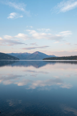 Mountain lake with reflection in water and blue sky at sunset.の素材