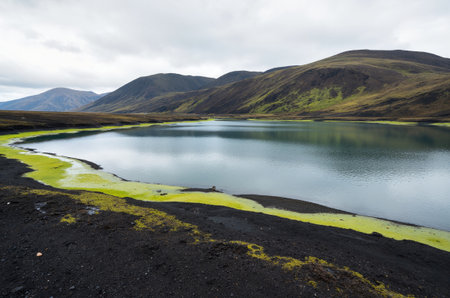 Icelandic landscape with lake and mountains in cloudy day. Icelandの素材