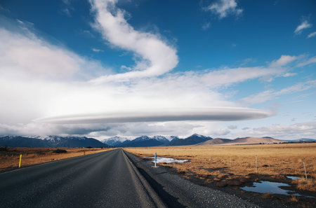 Icelandic landscape with road, mountains and blue sky with cloudsの素材