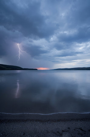 Dramatic stormy sky with lightning over a lake in Scotlandの素材