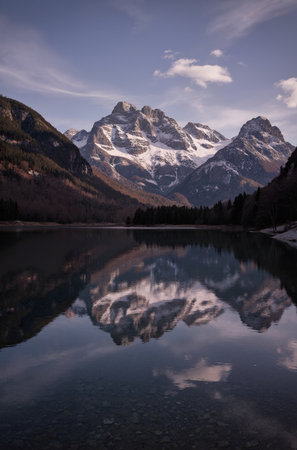 Mountain lake with reflection of snow and blue sky in autumn, Italyの素材