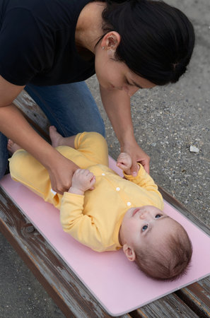 Asian mother playing with her baby on the playground in the park.の素材