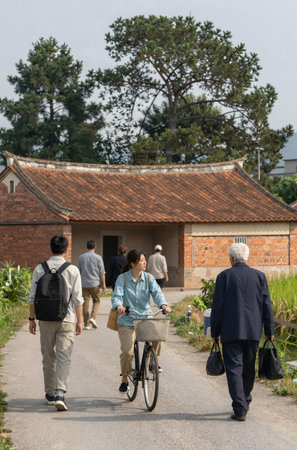 People walking in the garden with a bicycle and a house in the backgroundの素材