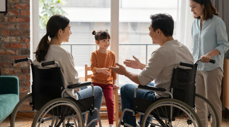 Disabled woman in wheelchair talking with her family in the living roomの素材
