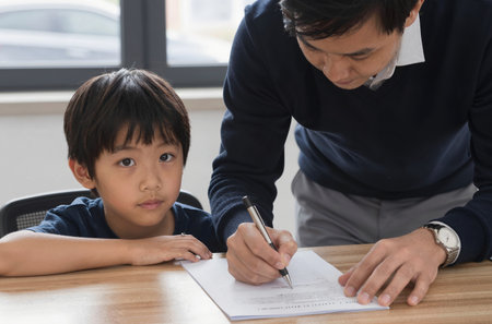 Asian father helping his son doing homework at home. Concept of family education.の素材