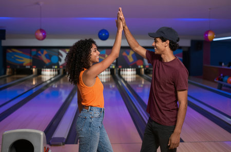 Young African-American couple playing bowling together at the club, having funの素材