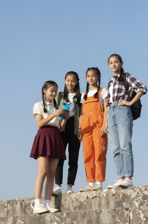 Portrait of asian elementary school students standing together against blue skyの素材