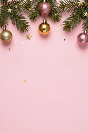 Christmas background with fir tree branches and decoration on pink background. Top view with copy spaceの素材