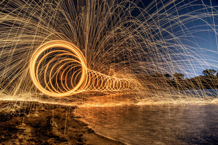 The work of glowing sparks from spinning steel wool by human.の写真素材