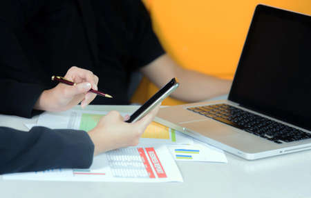 Close-up of smartphone in women hands using mobile phone in office, soft and select focus.の写真素材
