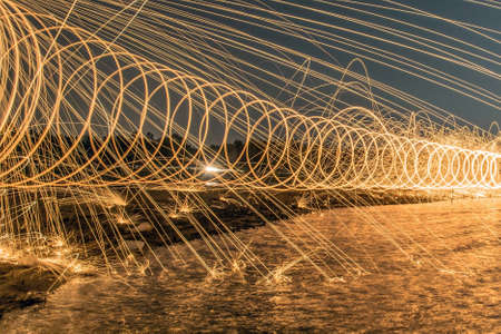 The work of glowing sparks from spinning steel wool by human.の写真素材