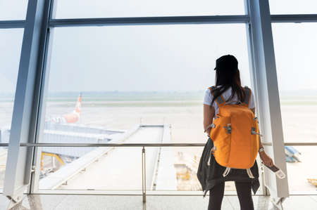 Woman waiting for a flight at the airport; window airport.の写真素材