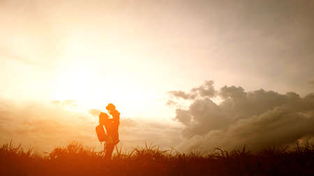 Silhouette of A mother and son playing outdoors at sunset.の写真素材