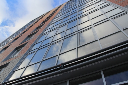 the high-rise building with glass windows, sky reflectionの写真素材