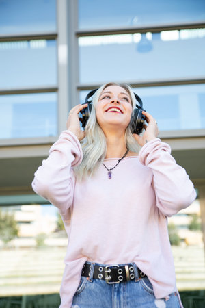 a young blonde woman chilling and enjoying music with headphones