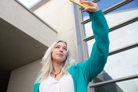 a professional young blonde woman using a smartphone. selfie