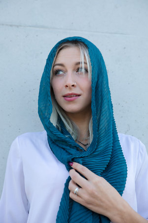 An elegant young beautiful blonde woman with a scarf