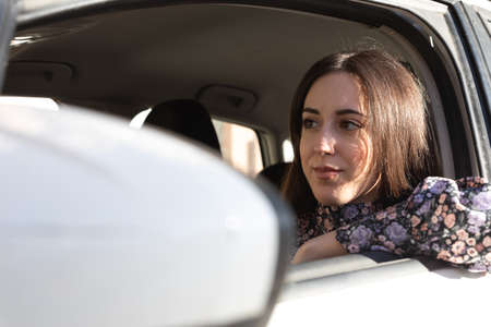Confident and happy young brunette lady driving in a carの写真素材