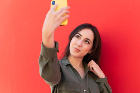 Young stylish brunette woman using an smartphoneの写真素材