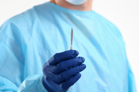 Man surgeon holds a scalpel.の写真素材