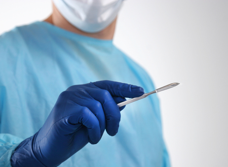 Man surgeon holds a scalpel.の写真素材