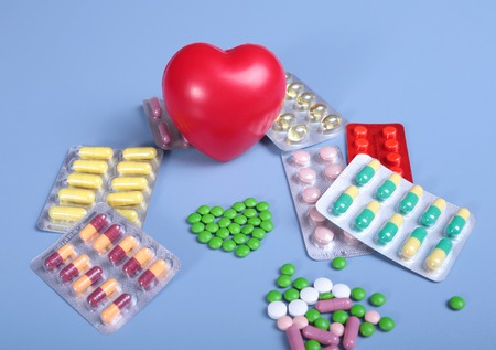 Packaging of tablets and pills on the table. Red heartの写真素材