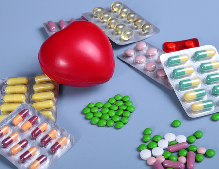 Packaging of tablets and pills on the table. Red heartの写真素材