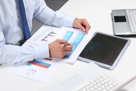 Business man sitting on the desk and working in his office.の写真素材