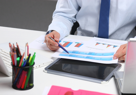 Business man sitting on the desk and working in his office.の写真素材