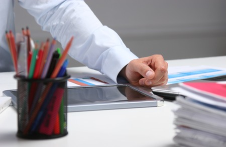 Business man sitting on the desk and working in his office.の写真素材