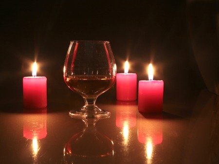 christmas photo cognac glass and candle on black background.の写真素材