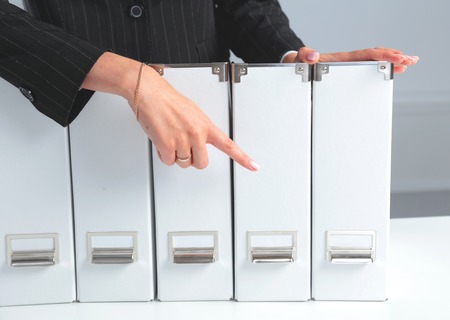 businessman holding data files on binder shelves background.の写真素材