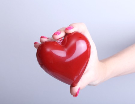 A doctor with stethoscope examining red heart, isolated on whiteの写真素材