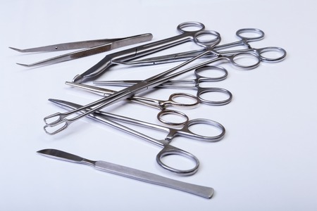 surgical instruments and tools including scalpels, forceps and tweezers arranged on a table for a surgery.の写真素材