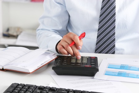 Businessman sitting on desk and writing a paperの写真素材