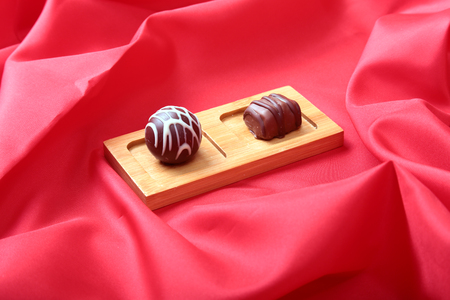 Coffee in white cup with chocolate pralines on red backgroundの写真素材