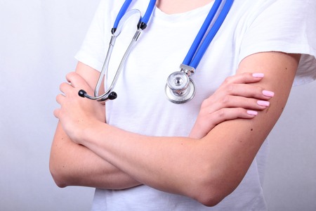 Portrait of a women doctor with stethoscope standing isolated on white backgroundの写真素材
