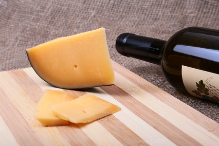 Still life with red wine grapes and chees on wooden table.の写真素材
