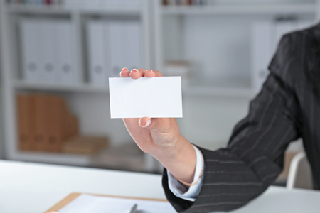 Businesswoman holding blank visit card ,sitting on the deskの写真素材