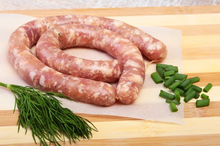 Homemade Raw sausage with spices on a wooden background.の写真素材