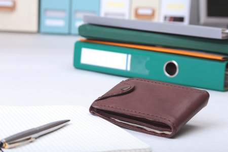 Folder file, note and wallet on the desk. blurred background.