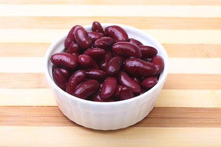 Heap of canned red kidney beans in the sauce in white bowl. vegetarian food. Phaseolus vulgaris.