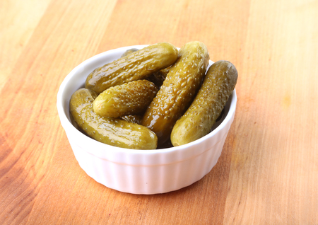 Bowl with pickled gherkins, cucumbers on wooden background close up. Pickles.の写真素材