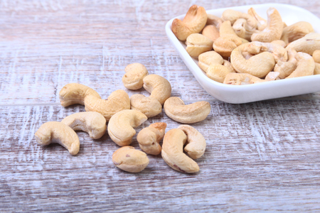 nuts cashews in white bowl on wooden background. Selective focus.の写真素材