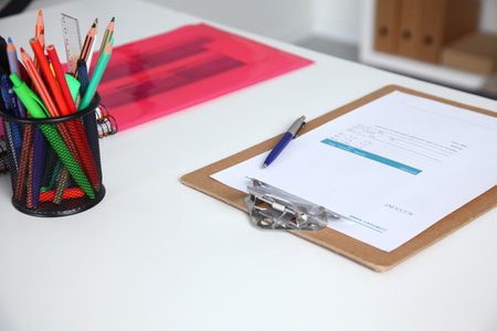 Closeup of white desktop with notepads, pen and other items. Selective focusの写真素材