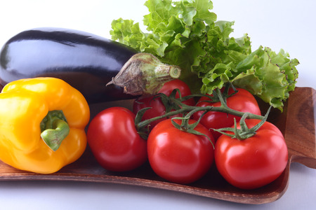 Fresh assorted vegetables, eggplant, bell pepper, tomato, garlic with leaf lettuce. Isolated on white background. Selective focus.の写真素材