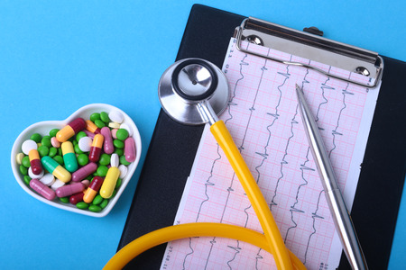 Stethoscope, RX prescription and colorful assortment pills and capsules on plateの写真素材