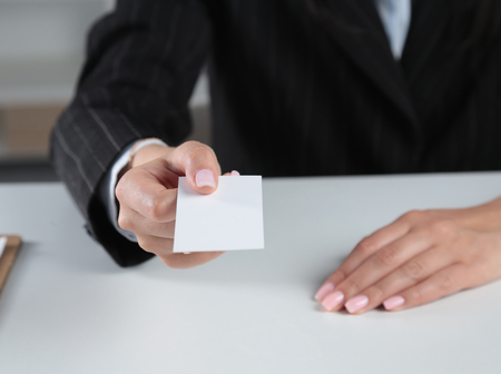 Businesswoman holding blank visit card ,sitting on the deskの写真素材